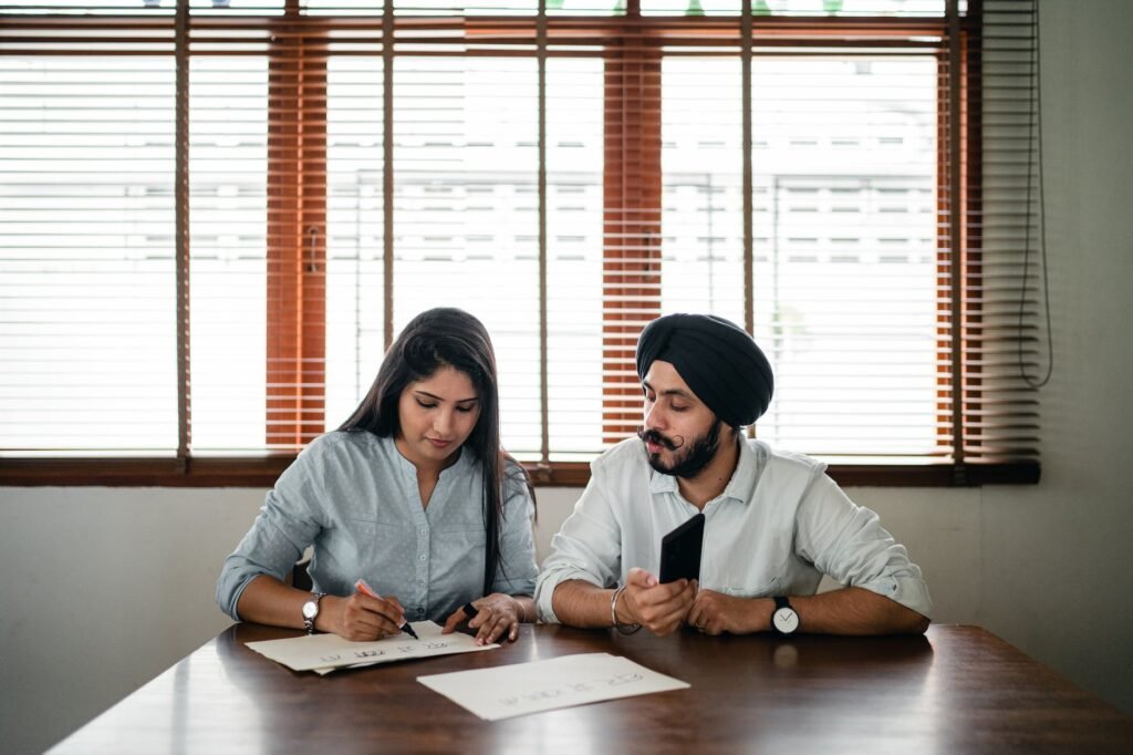 indian woman and man writing posters at table in light office